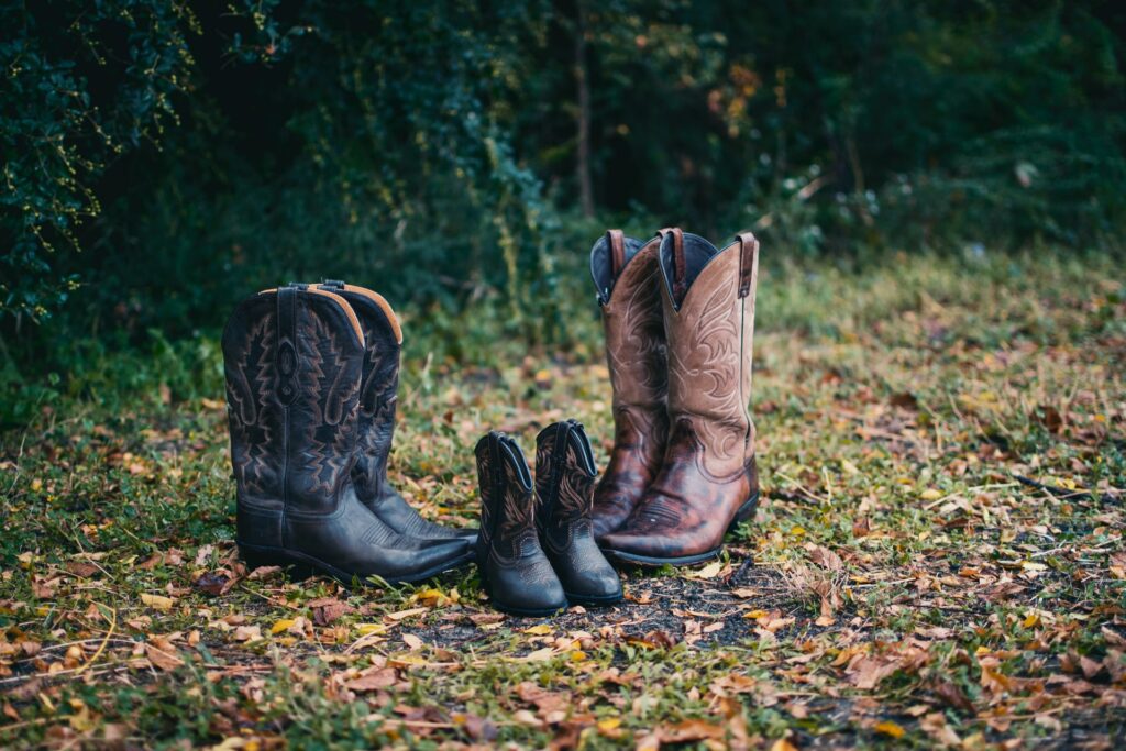 men womens and kids cowboy boots on green land