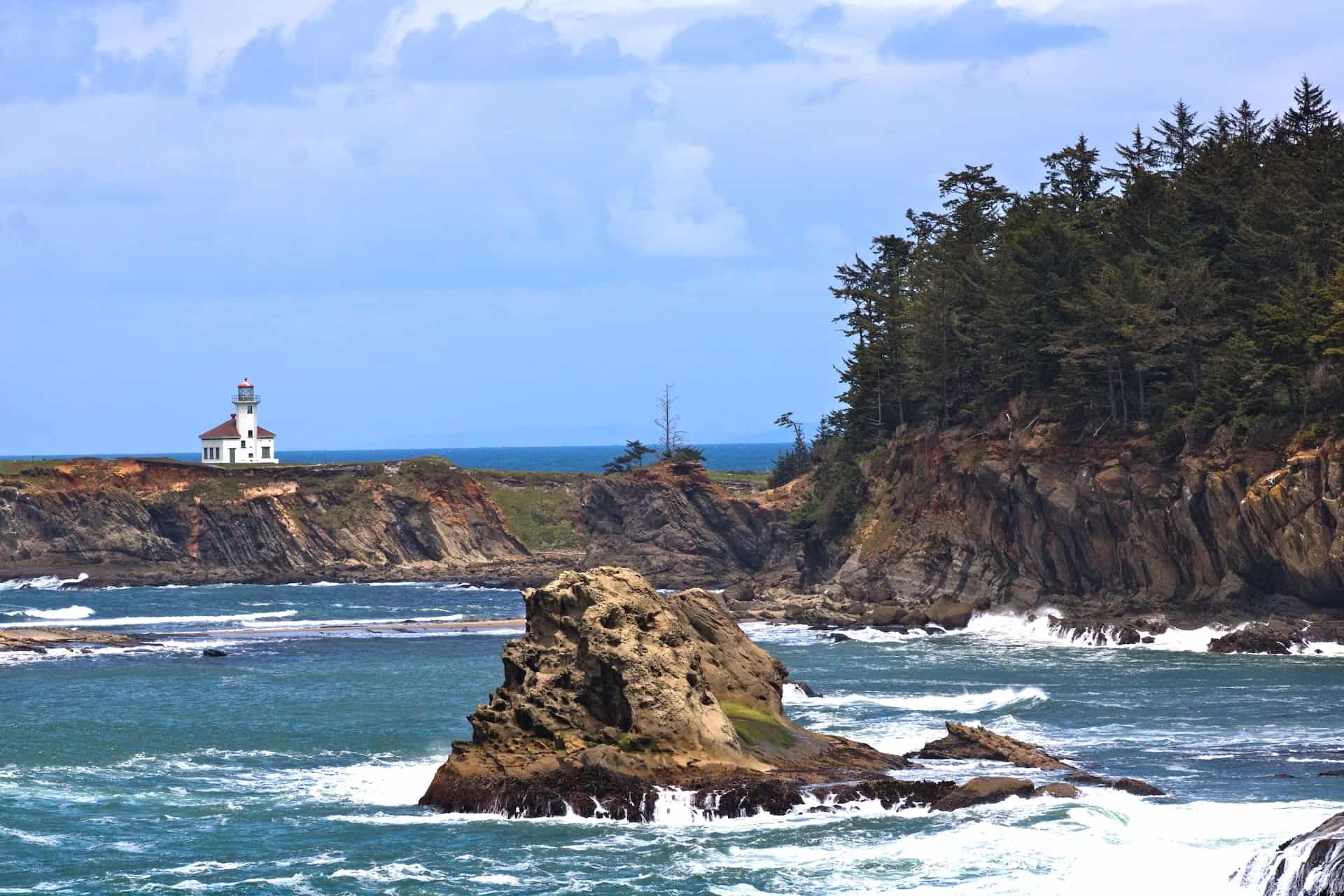 historic lighthouse on secluded rock along rocky coastline of the ocean