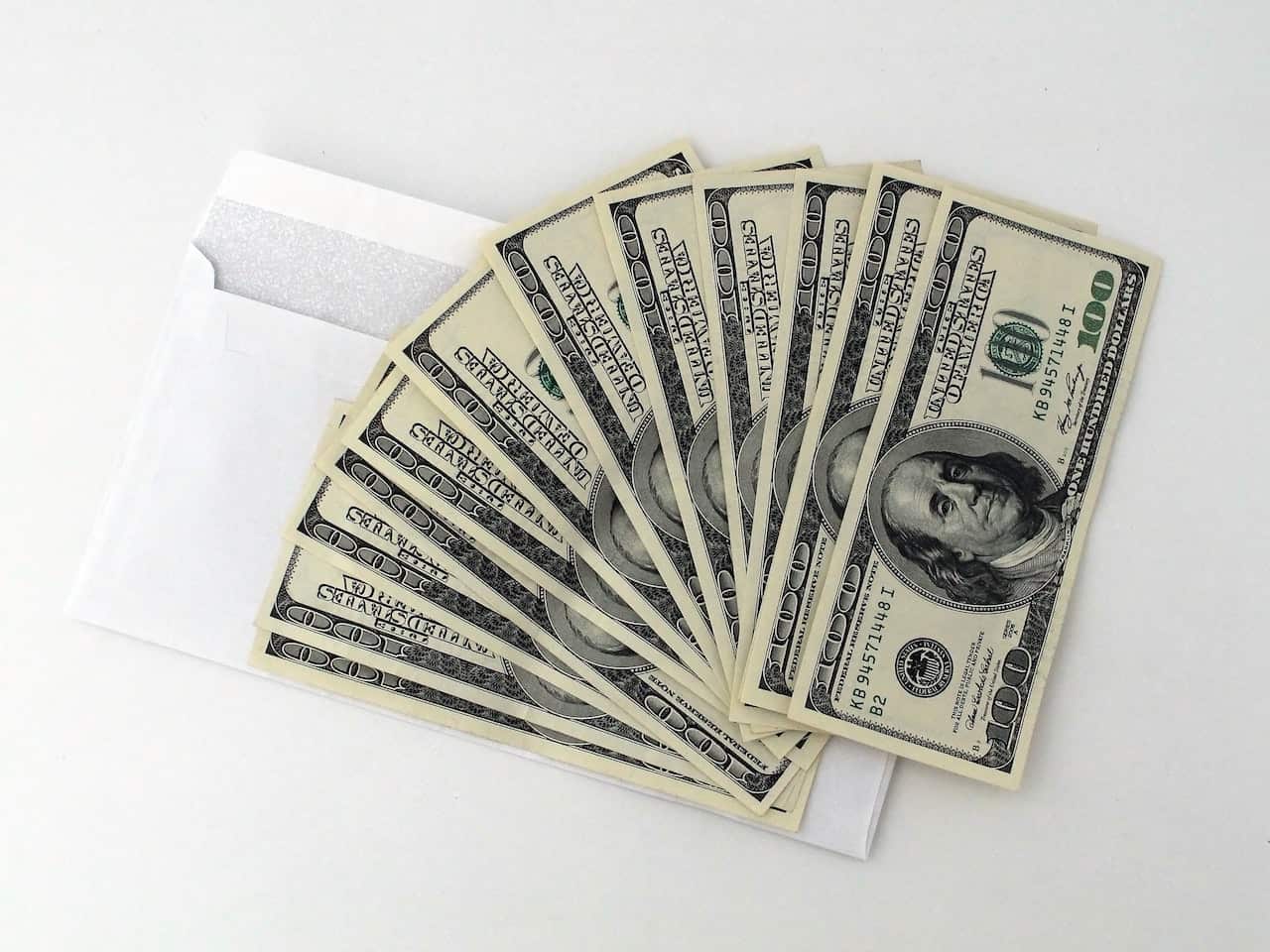 100 US Dollar Banknotes on top of white envelop 
