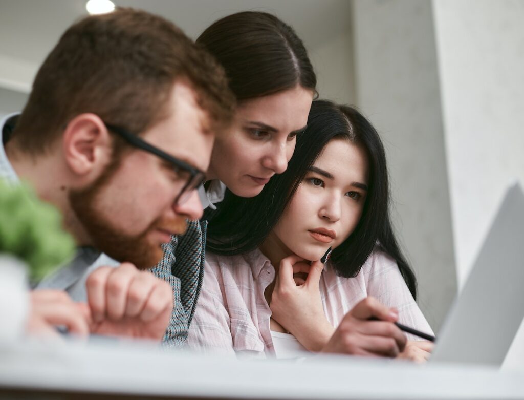 Three people looking at screen on how to finance land without taking loan